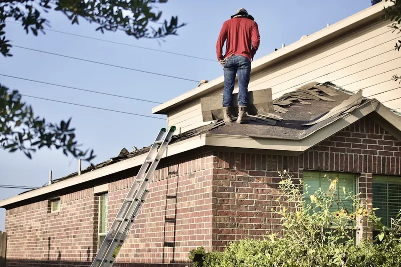 Professional roofer working on a residential roof in Queen